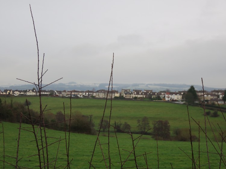 View across the valley with snow-crowned hills beyond